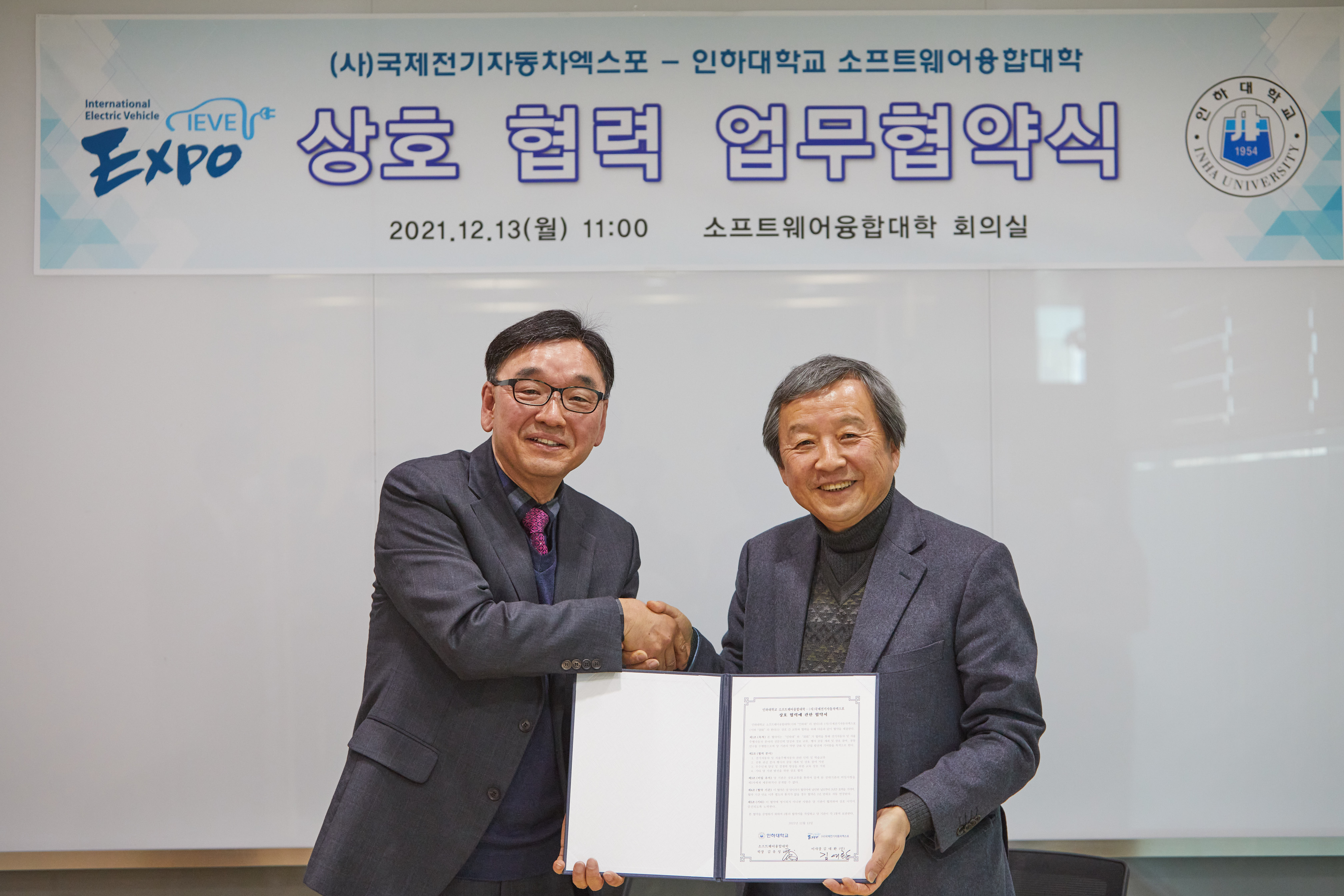 김유성 소프트웨어융합대학 학장(왼쪽)과 김대환 (사)국제전기자동차엑스포 이사장이 협약서를 들고 기념촬영을 하고 있다. 